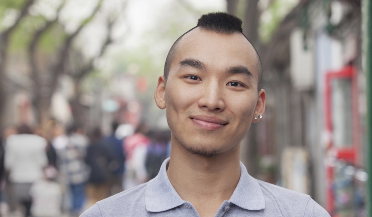 a man with a mohawk undercut wearing a back pack
