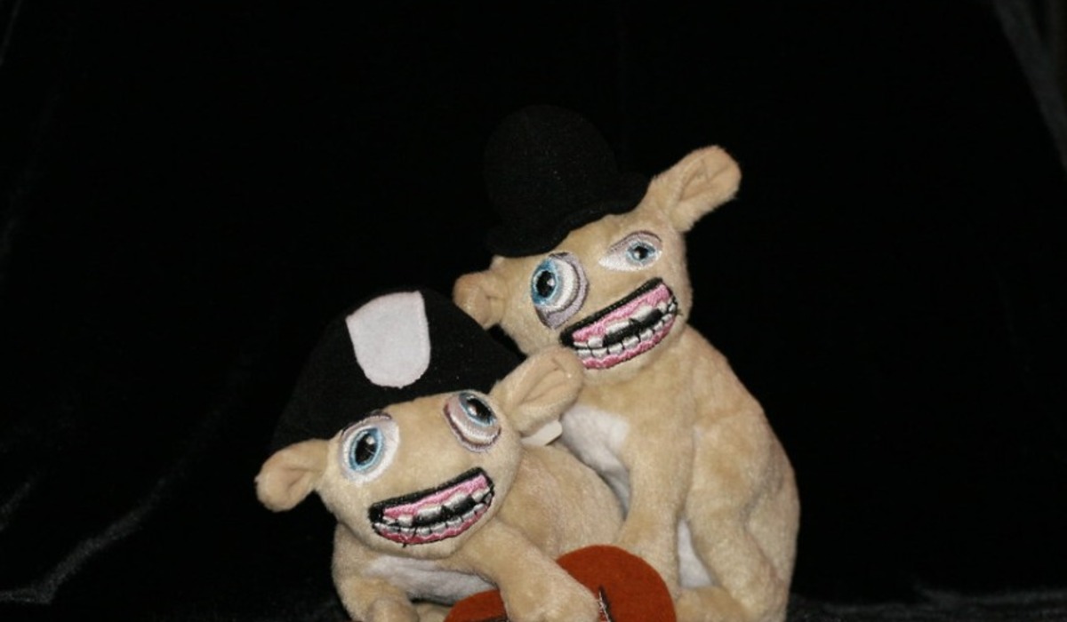 three assorted-color monkey plastic toys holding each other during daytime