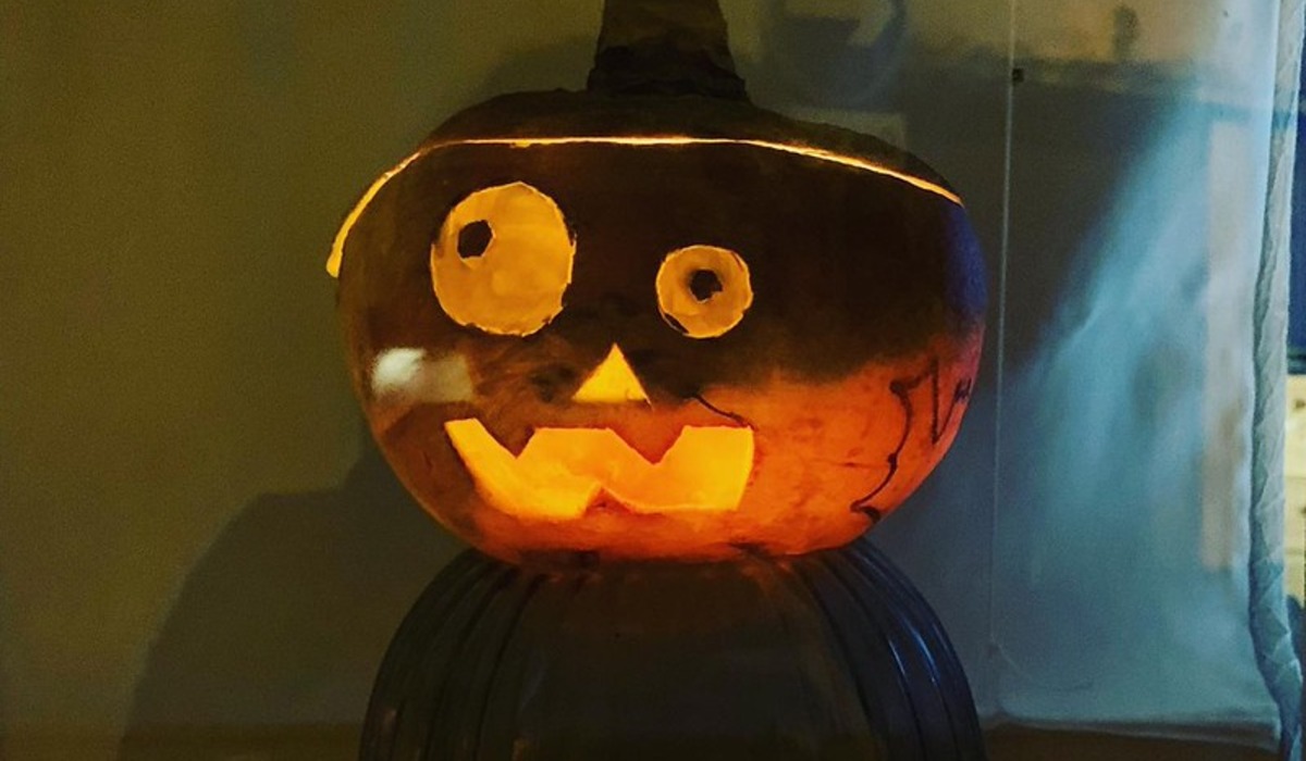 three carved pumpkins sitting in front of a brick wall