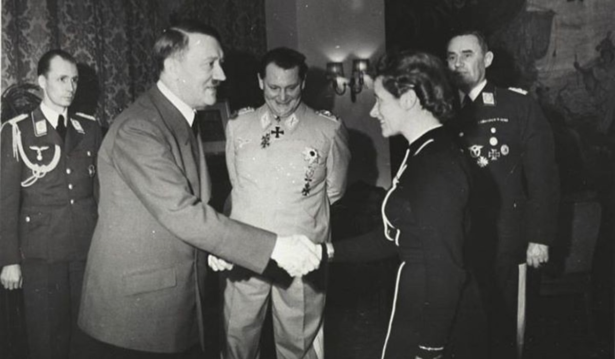 a couple of men standing next to each other in front of a plane