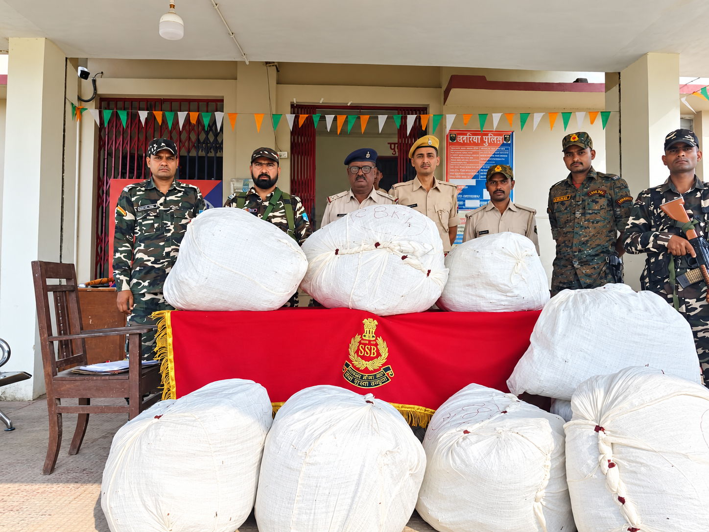 घुरना सीमा क्षेत्र में बरामद बंडलों के साथ एसएसबी और बिहार पुलिस के जवान। फोटो: प्रेस विज्ञप्ति के साथ प्राप्त तस्वीर (स्पष्टता हेतु संपादित)।