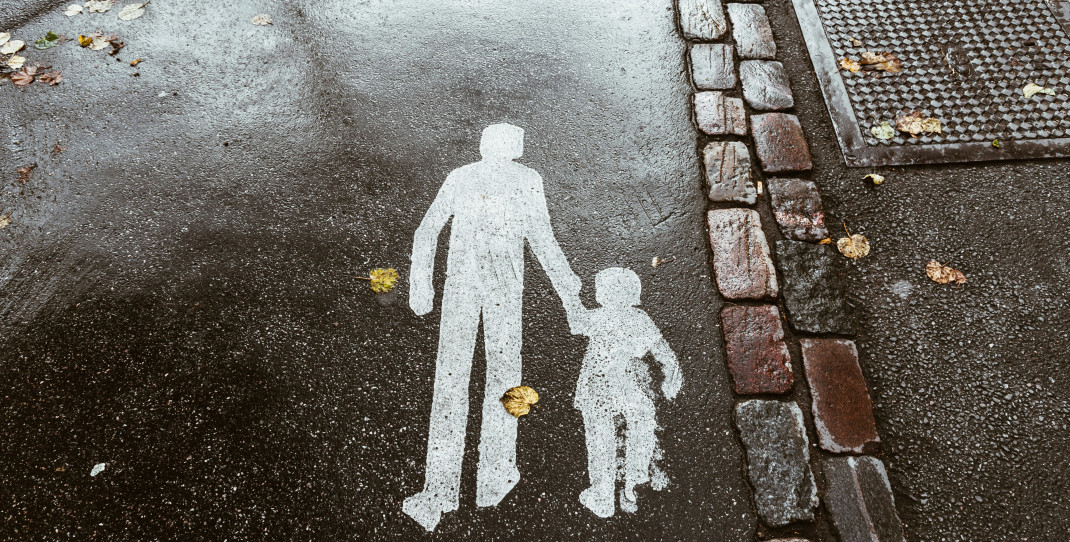Hvitt trykk på asfalt, voksen holder barn