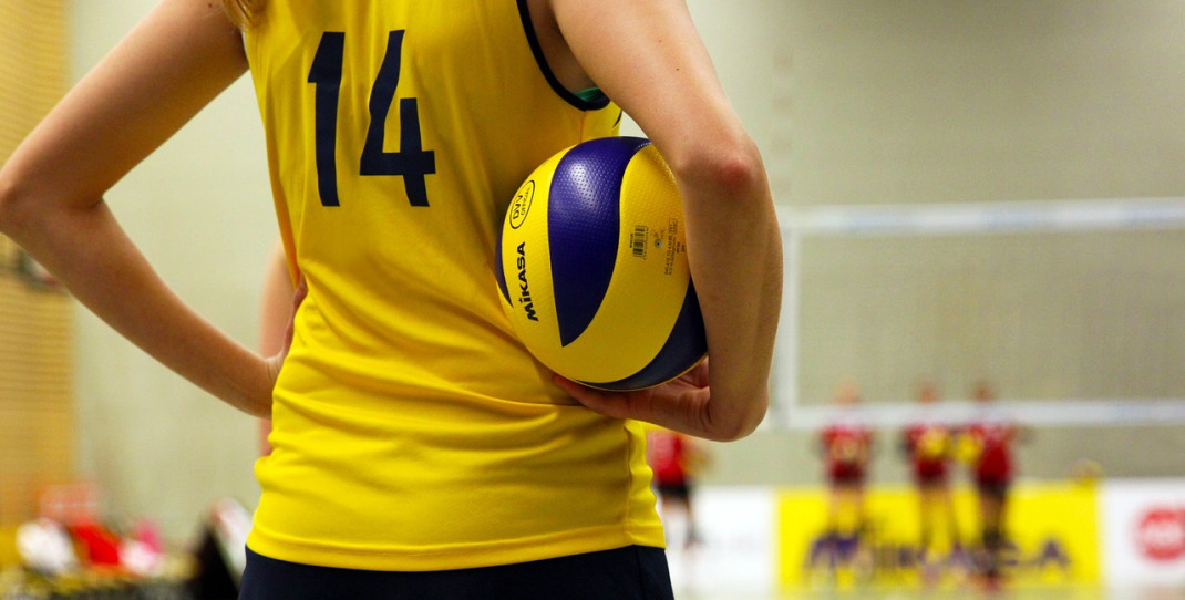 Volleyballutøver med ball under armen