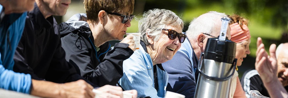 Gruppe mennesker som sitter ute og prater