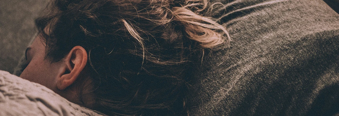Dame som ligger i sengen og sover