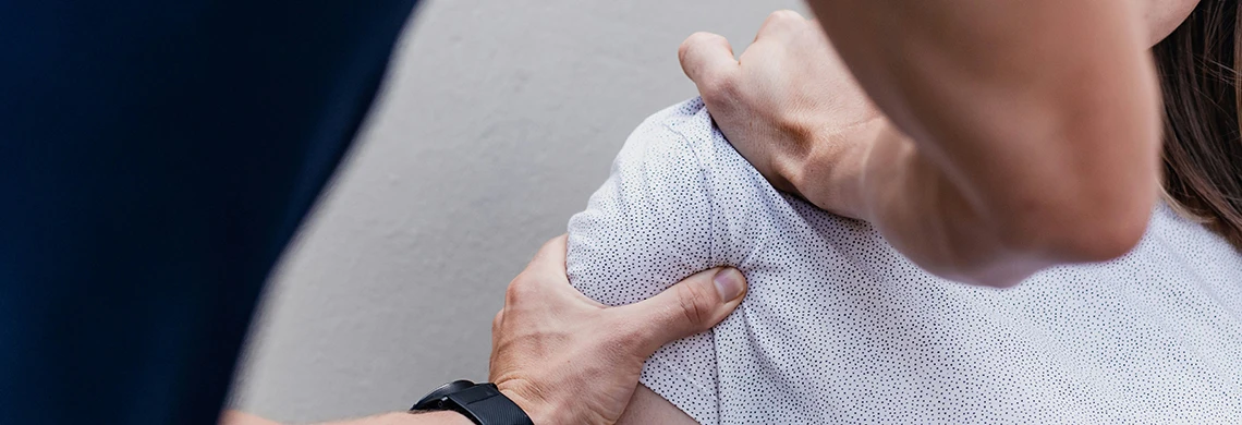 Dame som har vondt i skulderen