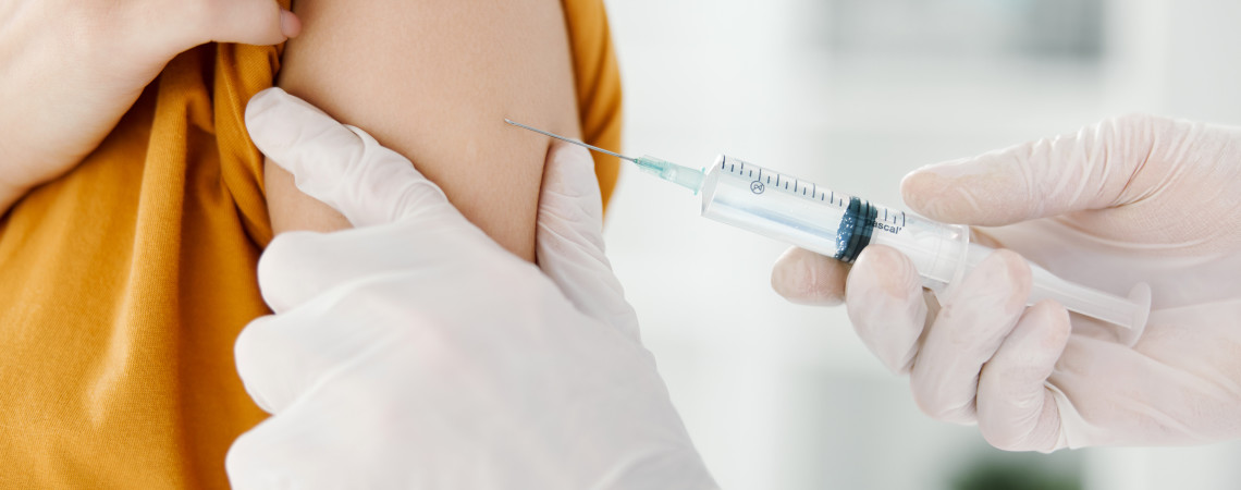 person som får vaksine og lege som setter sprøyten
