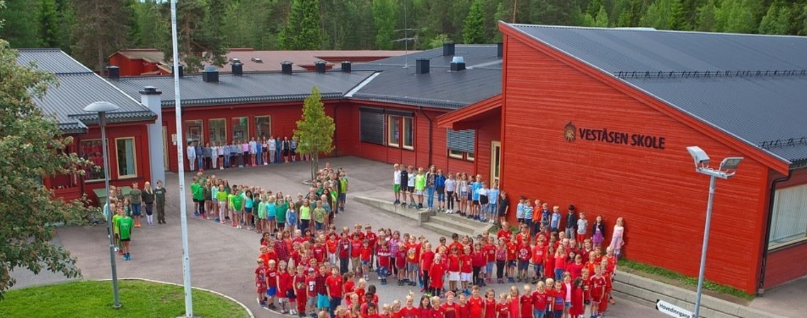 Elevene står i hjerteformasjon utenfor skolebygget