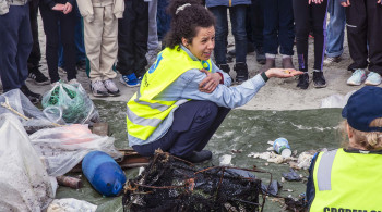 Forsker Rachel Leigh Davis fra USA og Universitetet i Tromsø, hjelper elever fra Grødem skole med å registrere mengden mikroplast på Sandestranda. Fredag var hun på stranda sammen med elever og ansatte fra 4C og hele syvendetrinnet for å hente ut prøver fra sanden.