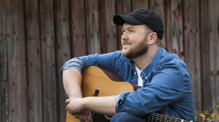 Bilde av artisten Arthur Stulien med gitar på fanget