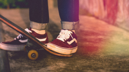 Bilde av bena til en ungdom på et skateboard.