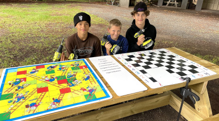 Bilde av de tre unge guttene og spillebordet de har laget