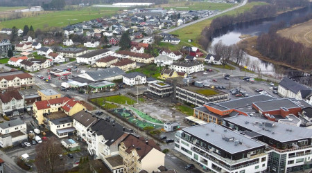 Dronefoto av Lyngdal rådhus og omkringliggende sentrumsbebyggelse