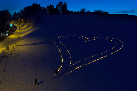 Dronefoto av et fakkelhjerte i snøen