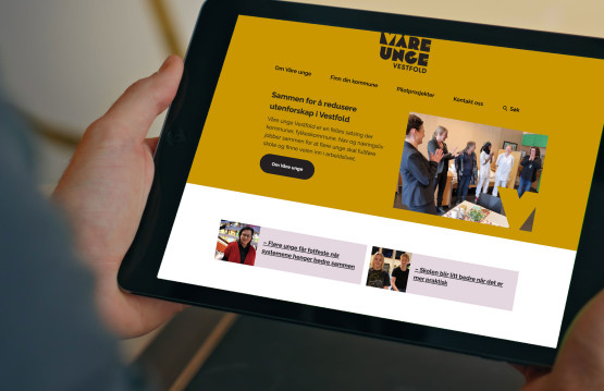 Person holder nettbrett med Våre unge-nettsiden synlig