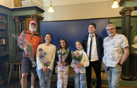 Bilde av filmteamet og skuespillerne etter premieren, med utdelte blomster.