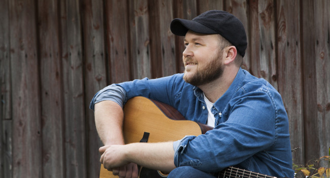 Bilde av artisten Arthur Stulien med gitar på fanget