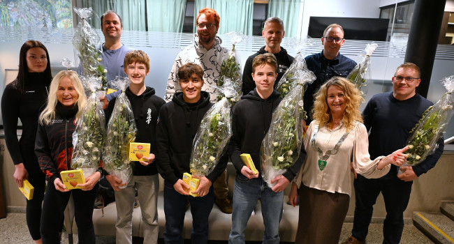 Gruppebilde av de lokale idrettsutøverne som ble hedret under kommunestyremøtet