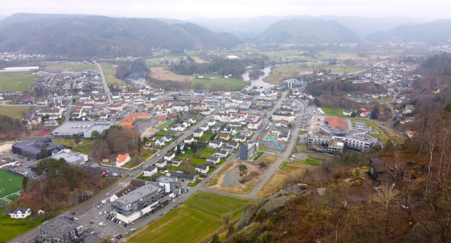 Dronefoto av Lyngdal sentrum med dagsturhytta i forgrunnen