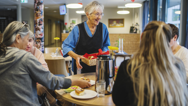 Besøkende i samtale rundt bord