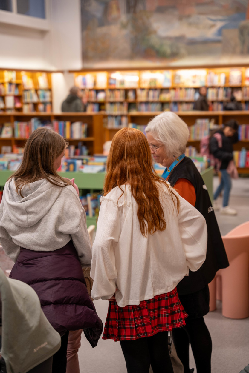 Fra åpningskvelden. Barnebibliotekar Tine Didriksen med unge besøkende.