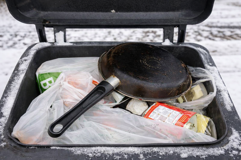 SORTER RIKTIG: Stekepanner har ingenting i beholderen for glass- og metallemballasje å gjøre. Det har heller ikke plastposene som synes på bildet. Sørg for å sortere riktig, slik at kostnadene kan holdes nede. (foto: Sarpsborg kommune)