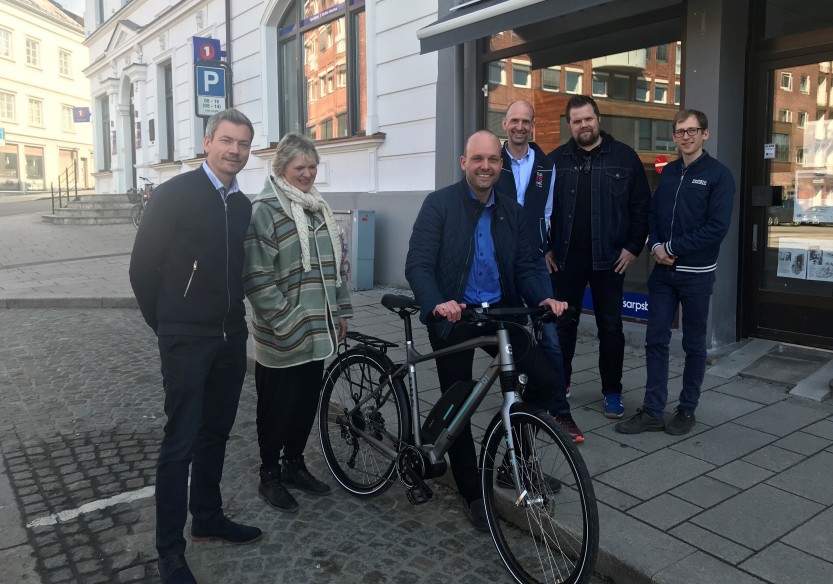 Ordfører Sindre Martinsen-Evje fikk overlevert el-sykkelen han skal lease av Lars Nordberg fra CycleEurope Norge, DBS (lengst til venstre i bildet). Marianne Knudsen, Per Bjørnar Wiig, Tor Magnus Østli og Jørgen Amos Ruud var også til stede fra kommunen. 