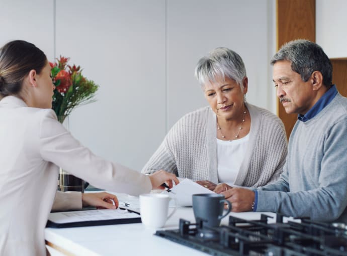 Shot of a senior couple meeting with an agent to discuss paperwork at home