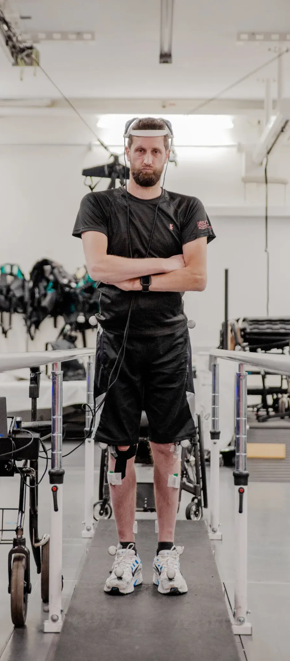 Gert-Jan Oskam is standing up with his arms crossed and a brain monitoring device on his head
