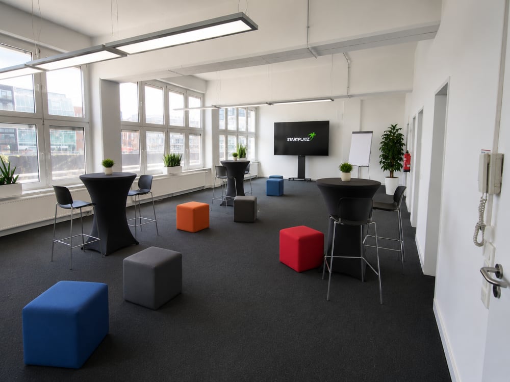 Raum Long Beach in Düsseldorf im Networking-Setup mit Stehtischen und Sitzwürfeln