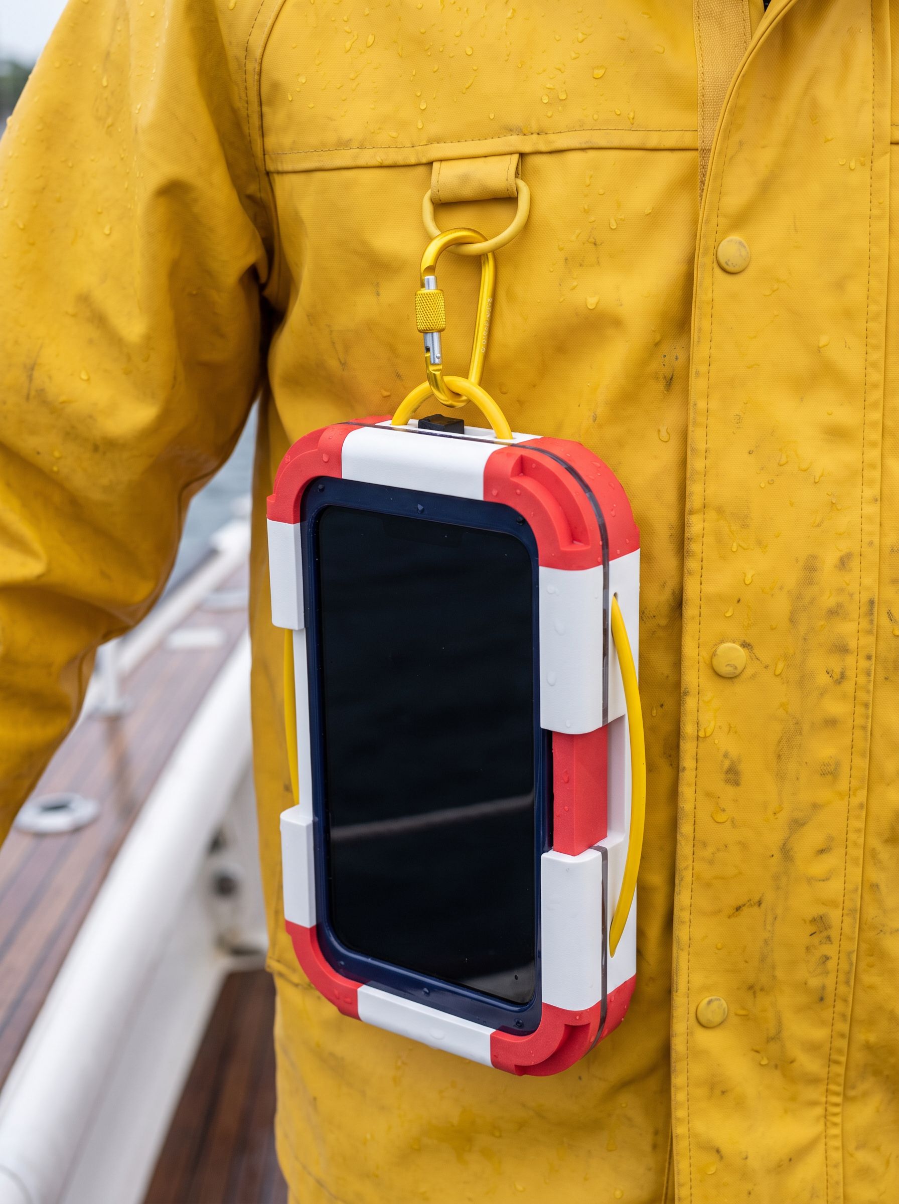 Close-up of SafeCase hanging from a yellow jacket by the carabiner