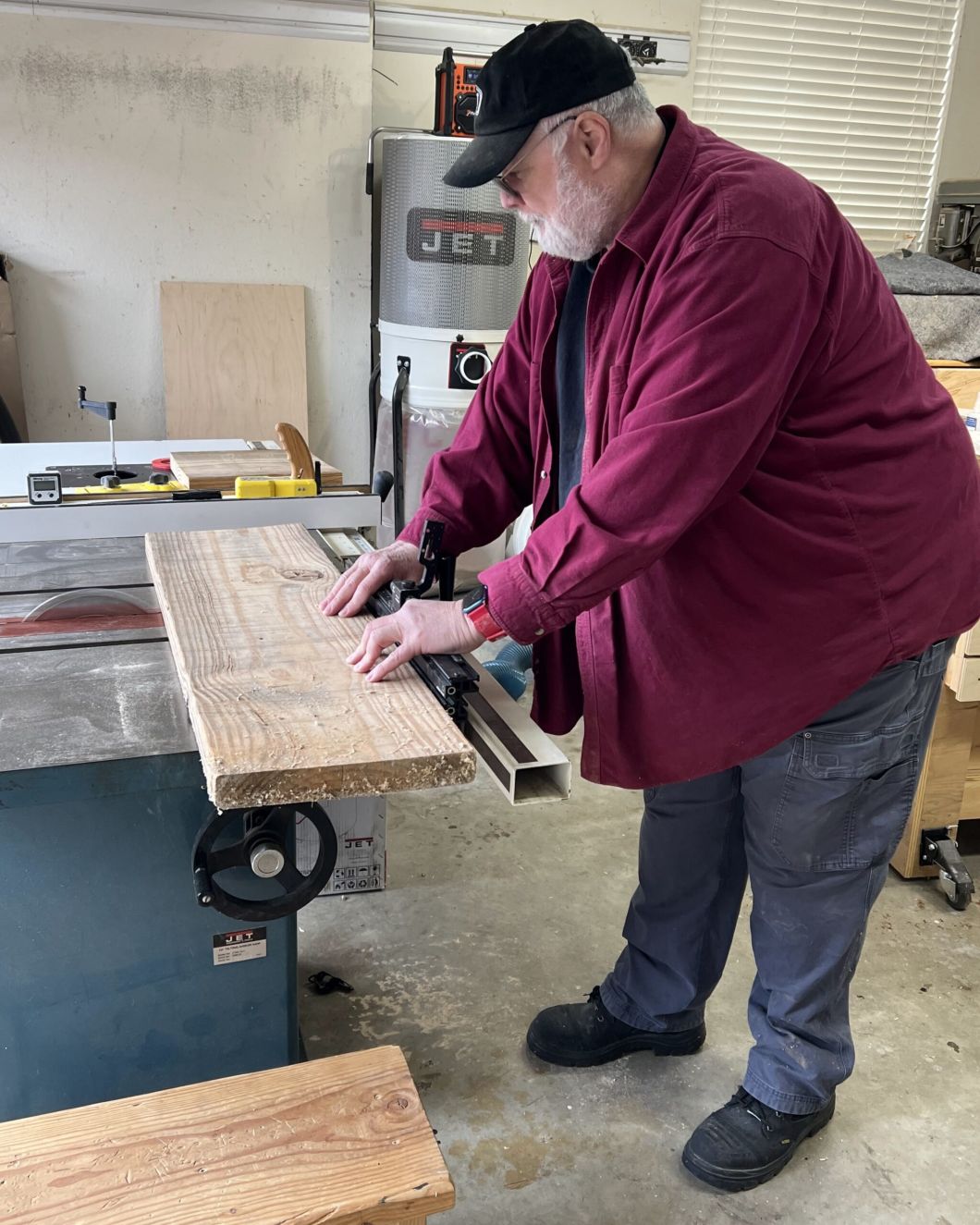 man wearing red jacket and Steel Blue boots using a wood cutting machine