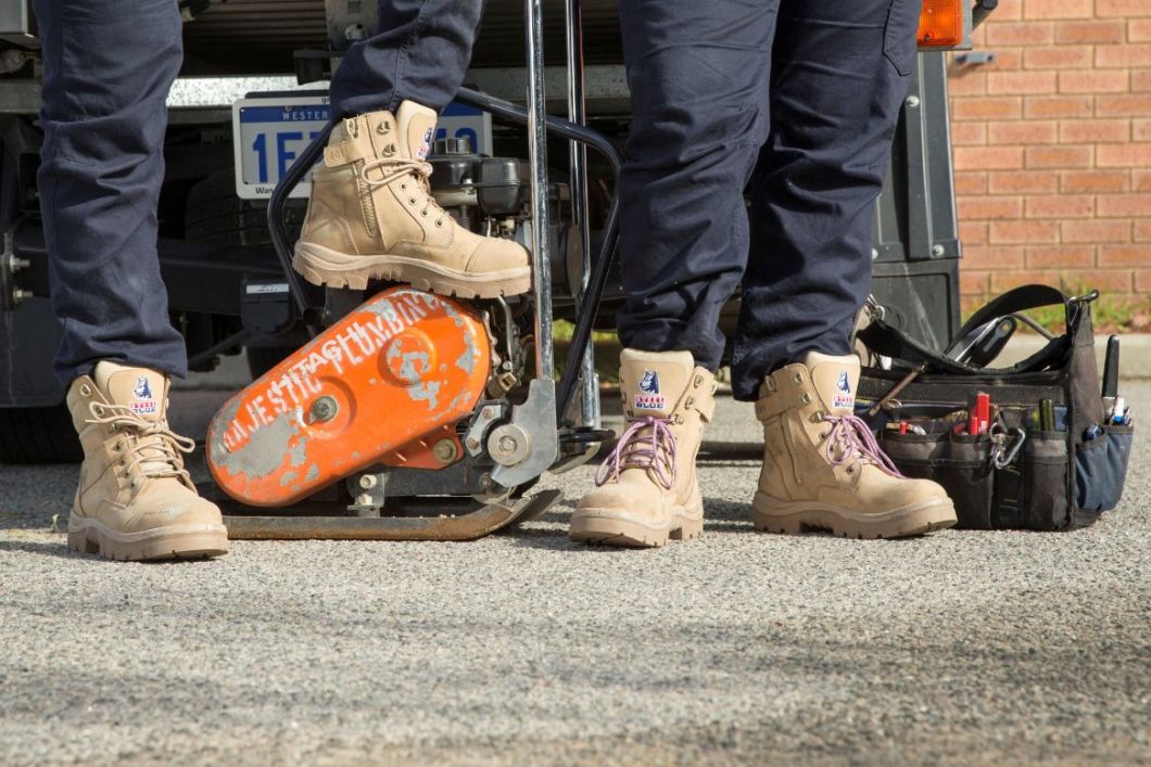 Zoomed in shot of Southern Cross Sand Men and Ladies boots near vehicle and equipment