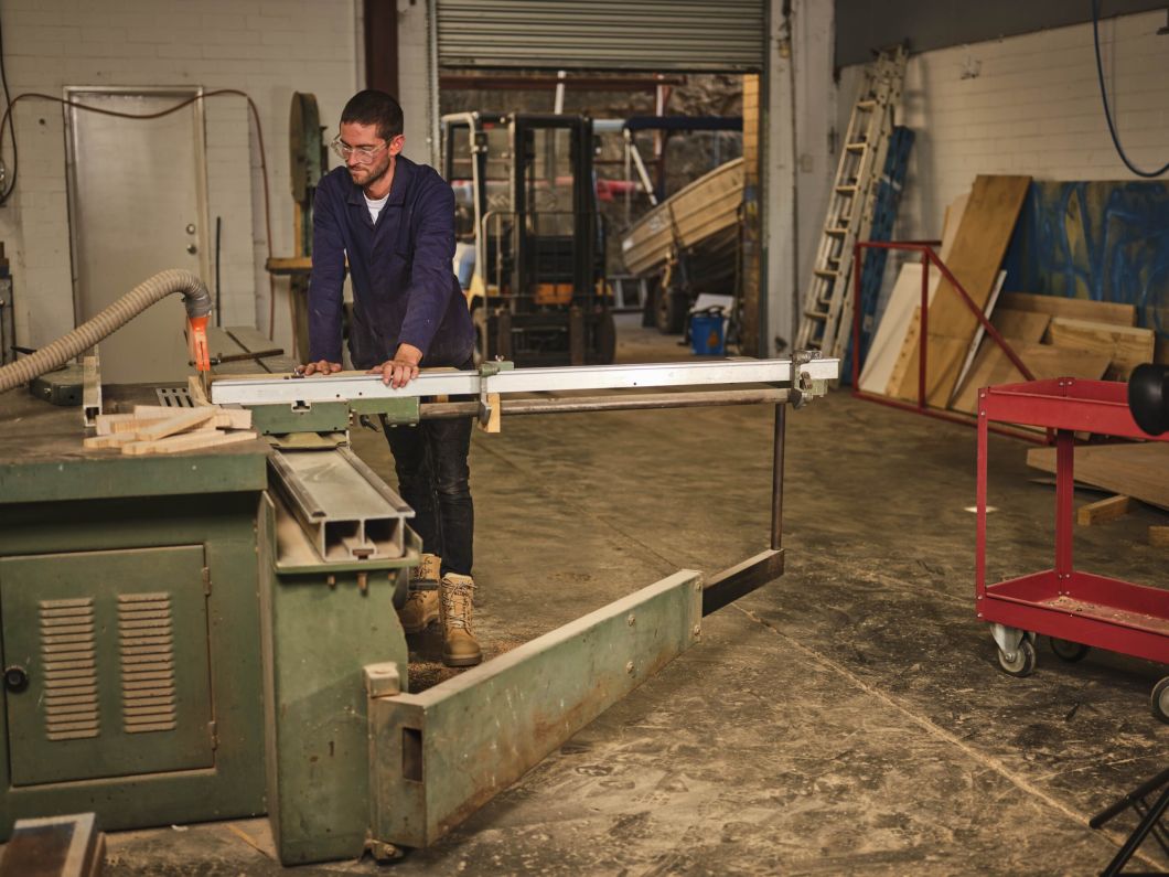 Man in a workshop wearing work boots by Steel blue