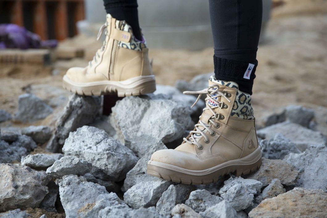 Feet wearing Southern Cross® Zip Ladies: Jungle Boots standing on rocks