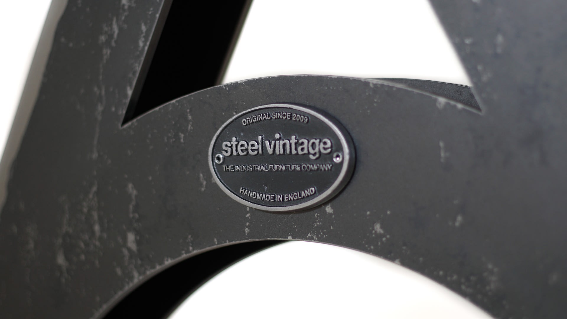 Steel Vintage wordsmith table closeup of badge