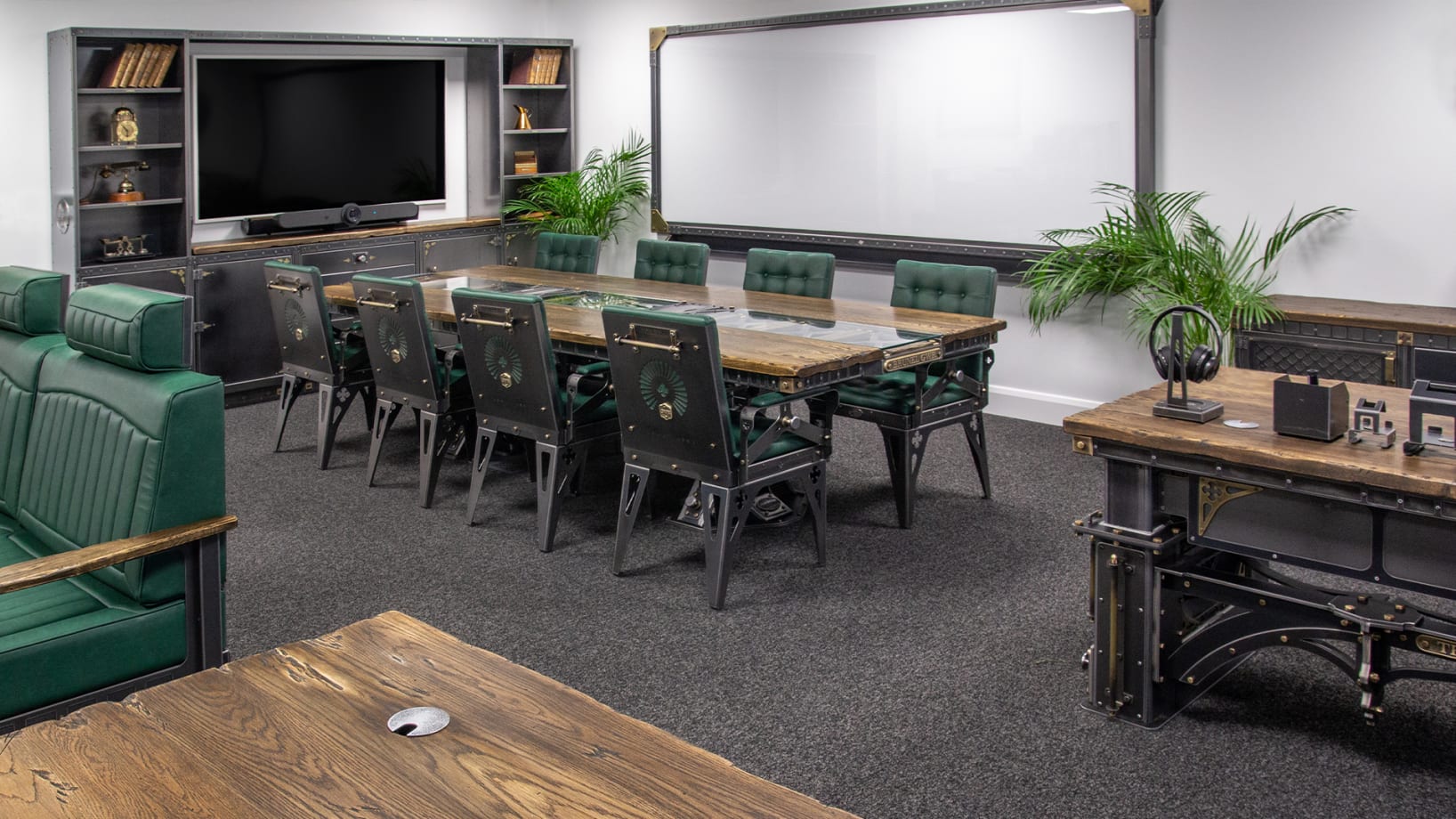 boardroom set up including industrial style chairs, table, tv unit & glass board