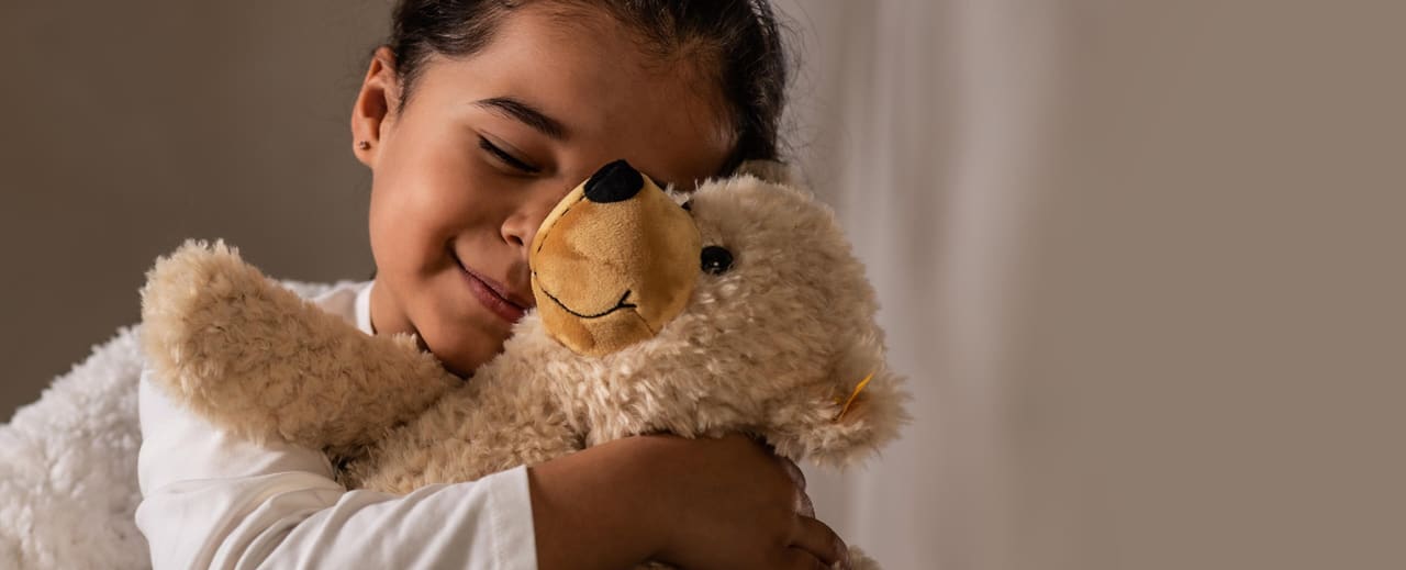 Kind kuschelt mit steiff teddy teaser