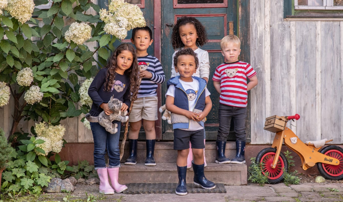 Gruppe kinder mit shirts mit steiff baer