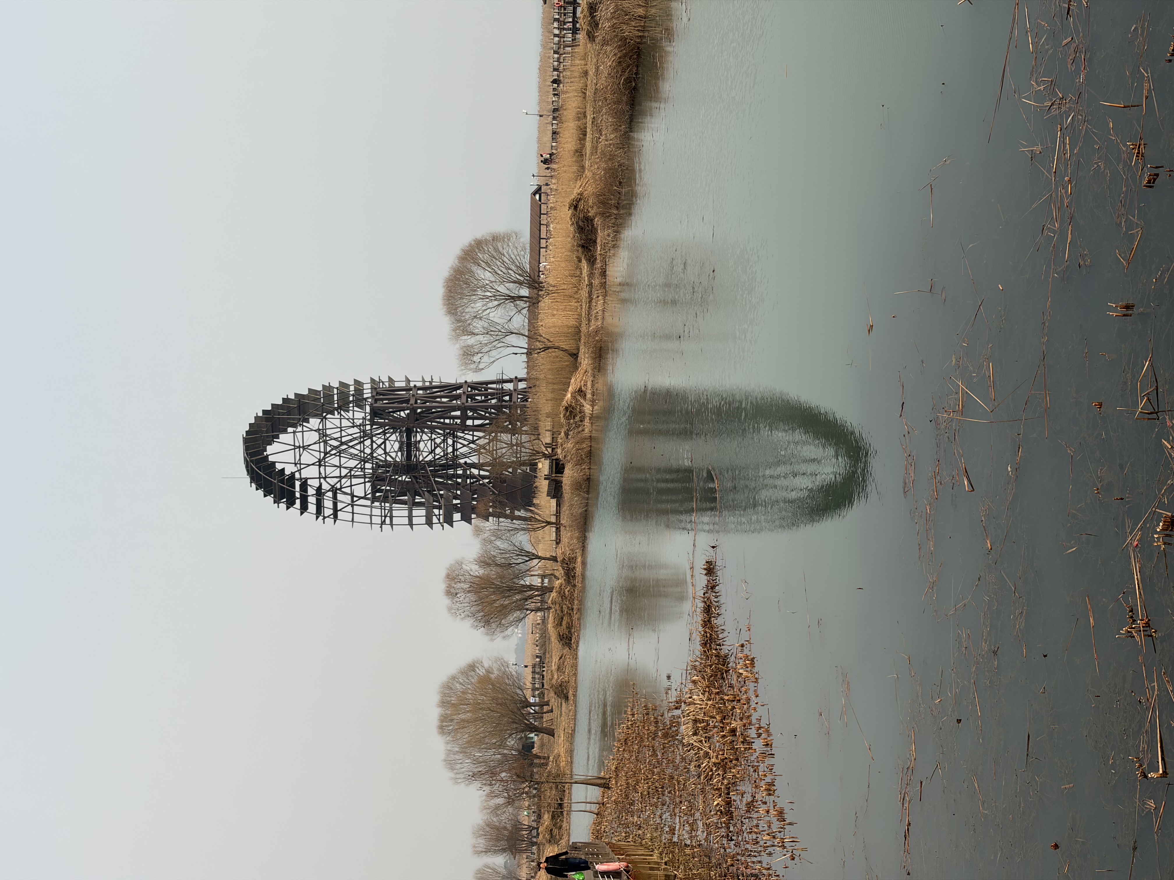 A water wheel and its reflection on water