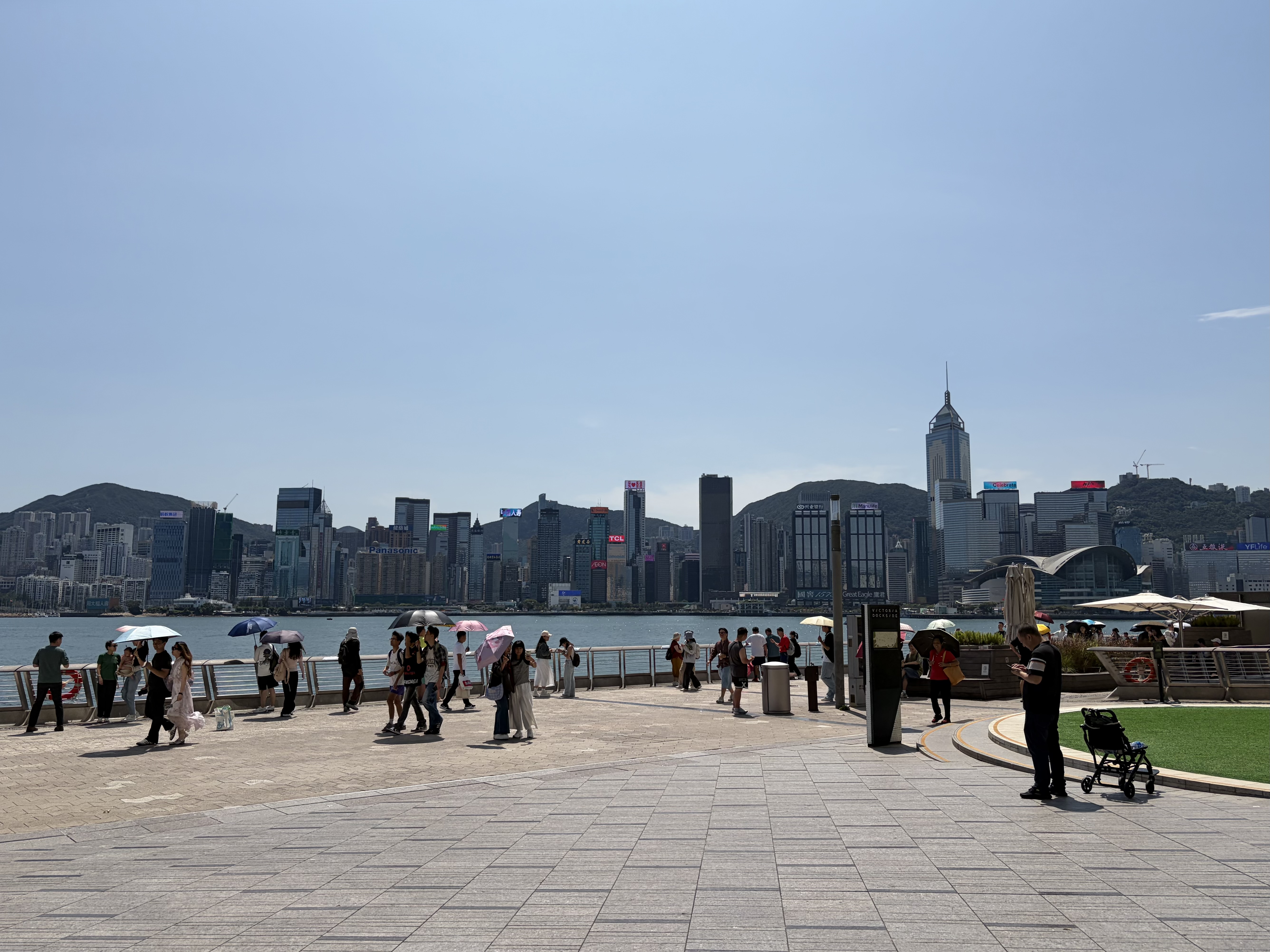 A harbor in Hong Kong, filled with people walking.