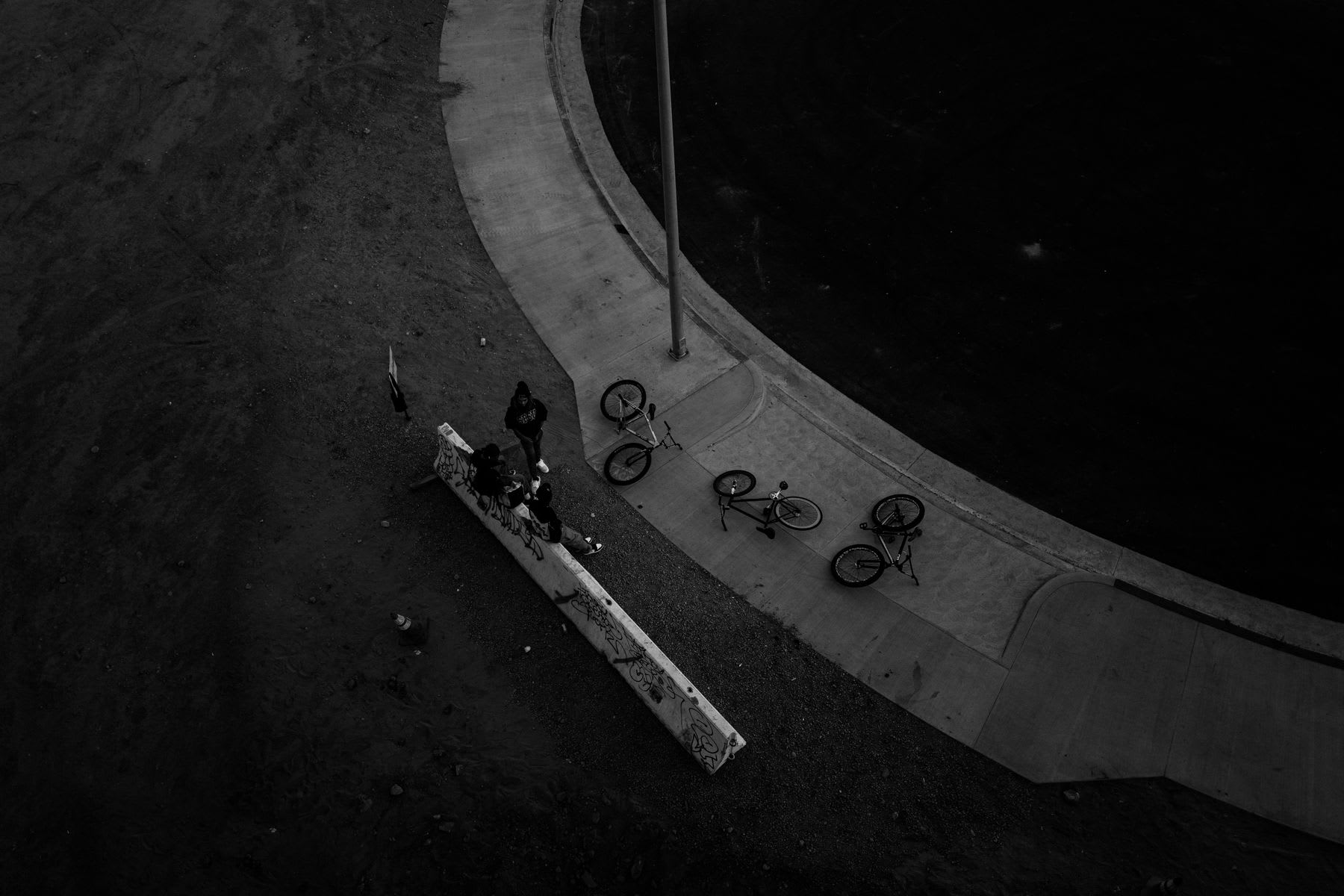 Three bicycles are scattered on the floor in a dimly lit environment