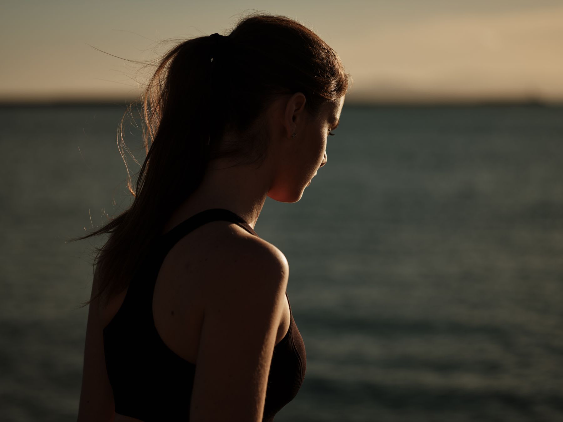 A young women is staring into the water.