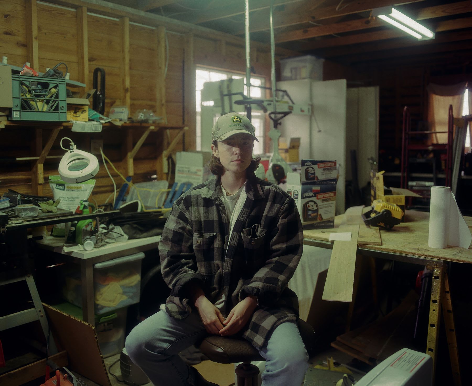 Woman sits in a woodworking workshop during the daytime.
