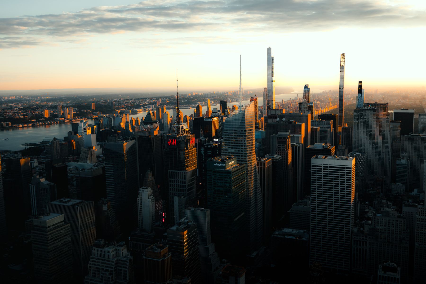 A city skyline with numerous high-rise buildings and skyscrapers is seen at sundown.
