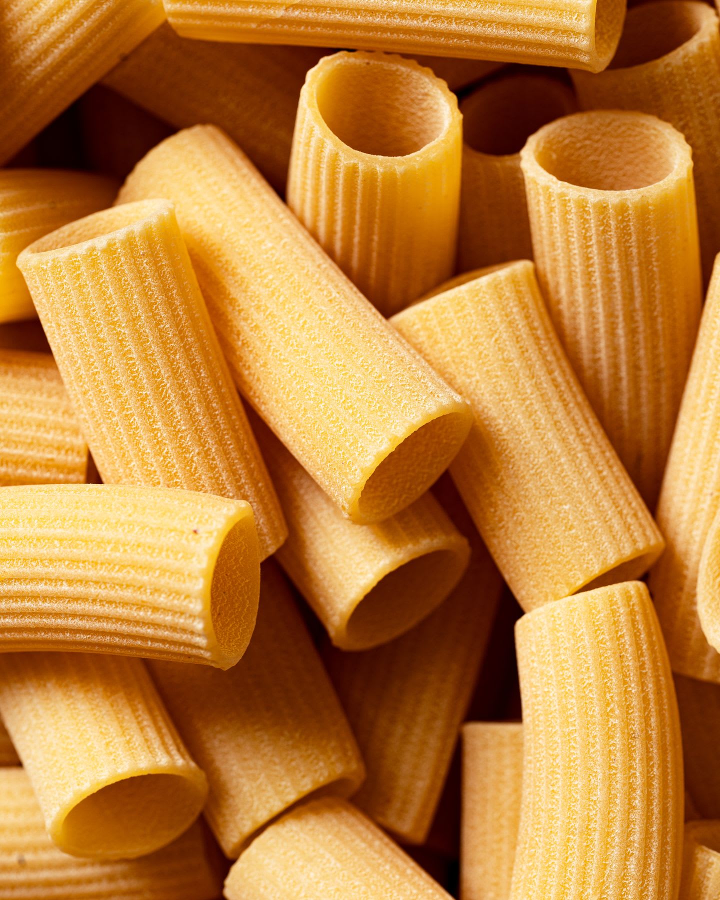 Container filled with dry rigatoni pasta