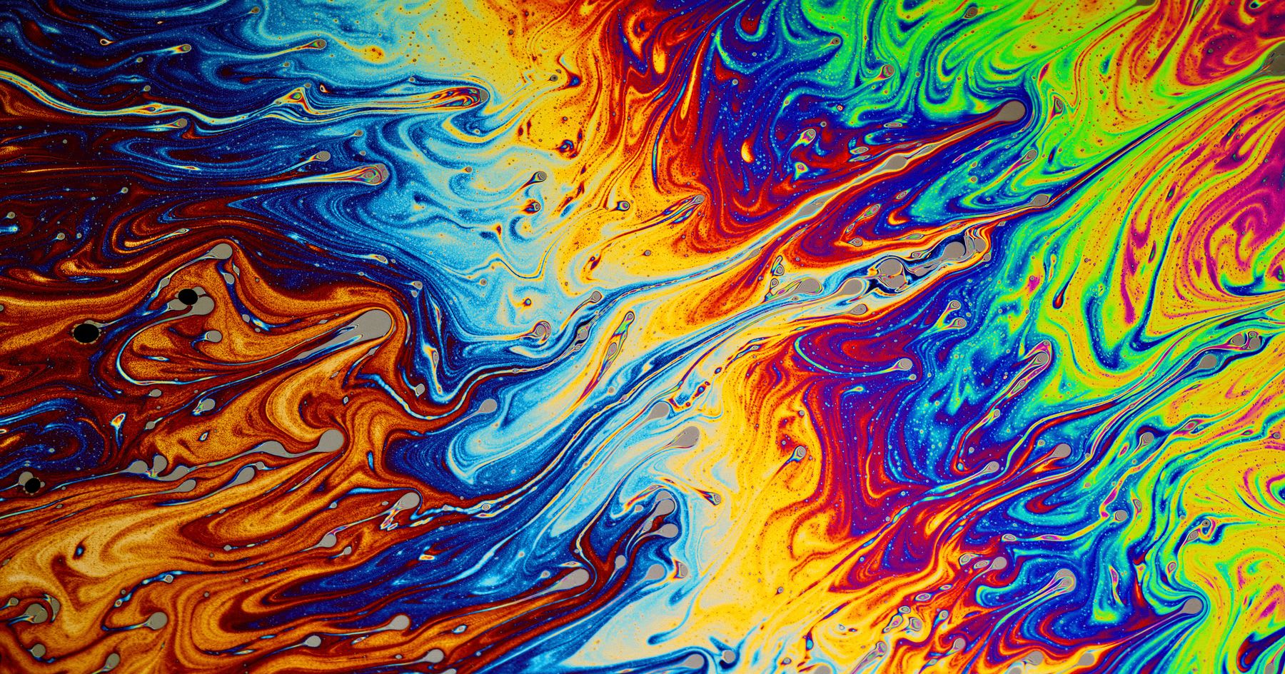 Abstract colorful swirls of an oil slick on water.