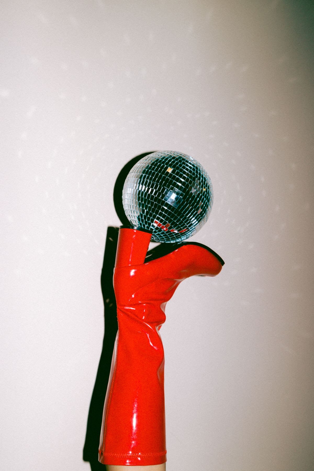 a pair of red boots holding a disco ball