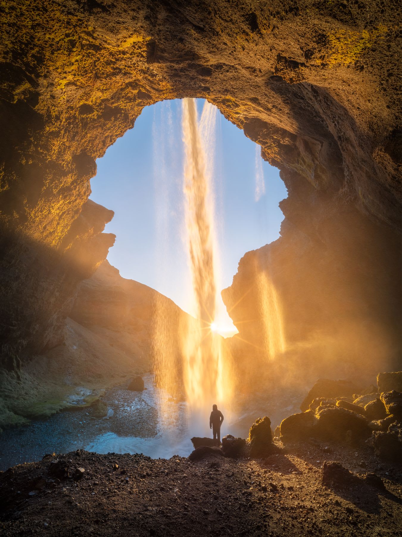 A person standing under a waterfall