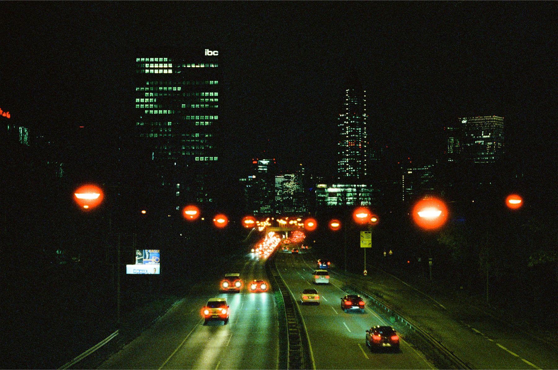 A view of some cars driving into a city at night